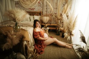 Femme enceinte allongée sur une couverture en macramé pour une séance photo