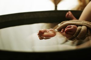 Bain enveloppé pour un nouveau-né avec luxation de la hanche, bébé emmailloté flottant dans l’eau chaude