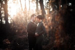 Couple tendrement enlacé lors d’un shooting grossesse en hiver