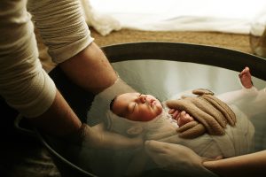 Focus sur les jambes du nouveau-né dans le lange CALIN, montrant le respect de la posture médicale